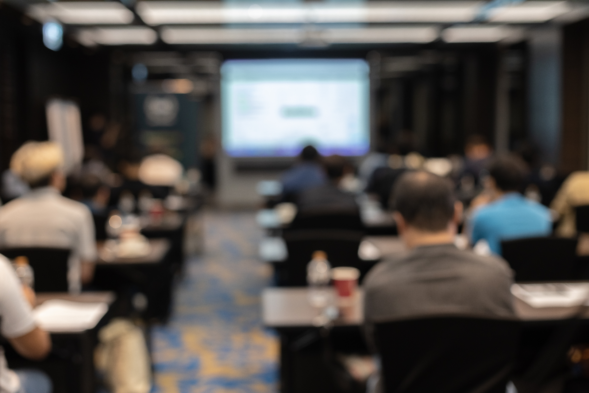 Professionals attending an Capital Contracts training seminar in a modern conference room